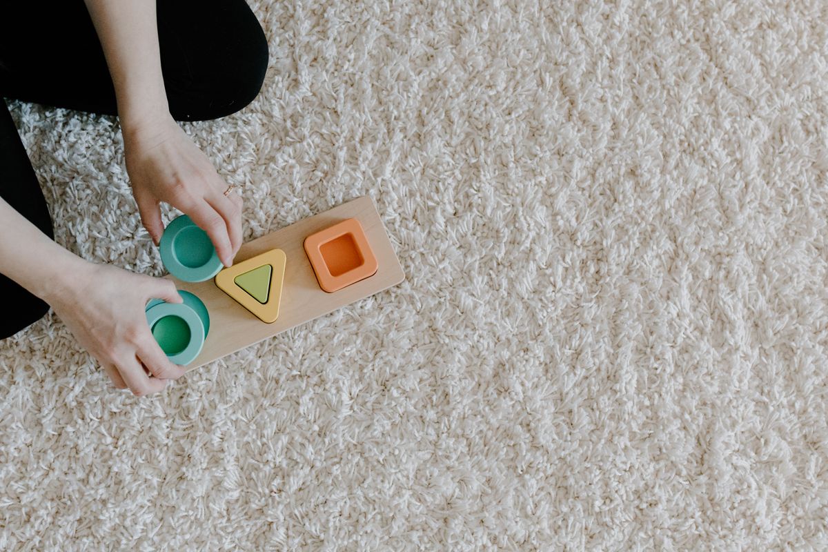 Child playing with a wooden shape sorter puzzle